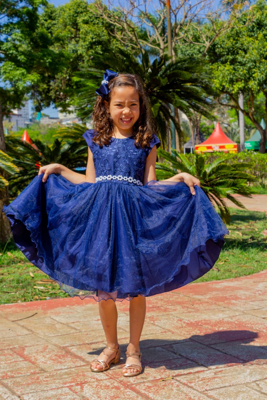 A delicadeza de uma bebê e uma menina vestidas com vestido realza sua beleza e seu charme.